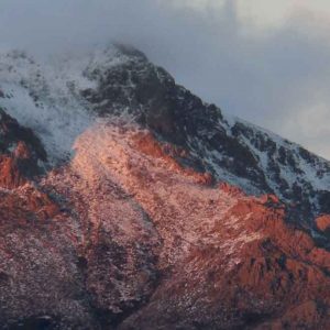 Imagen de la montaña Maliciosa al atardecer con nieve y nubes en la cumbre